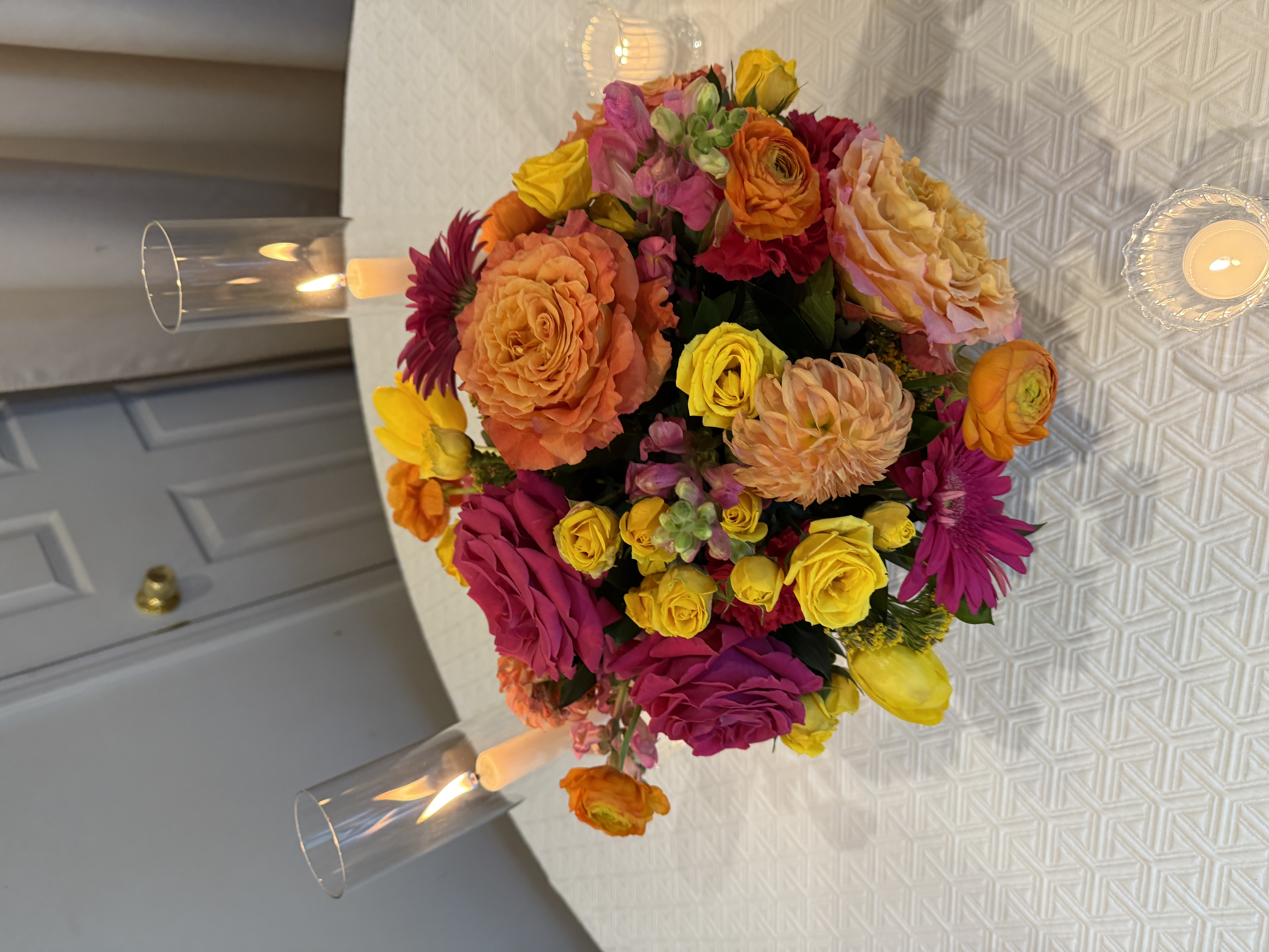 Bright pink, orange, and yellow flower bouquet on a table