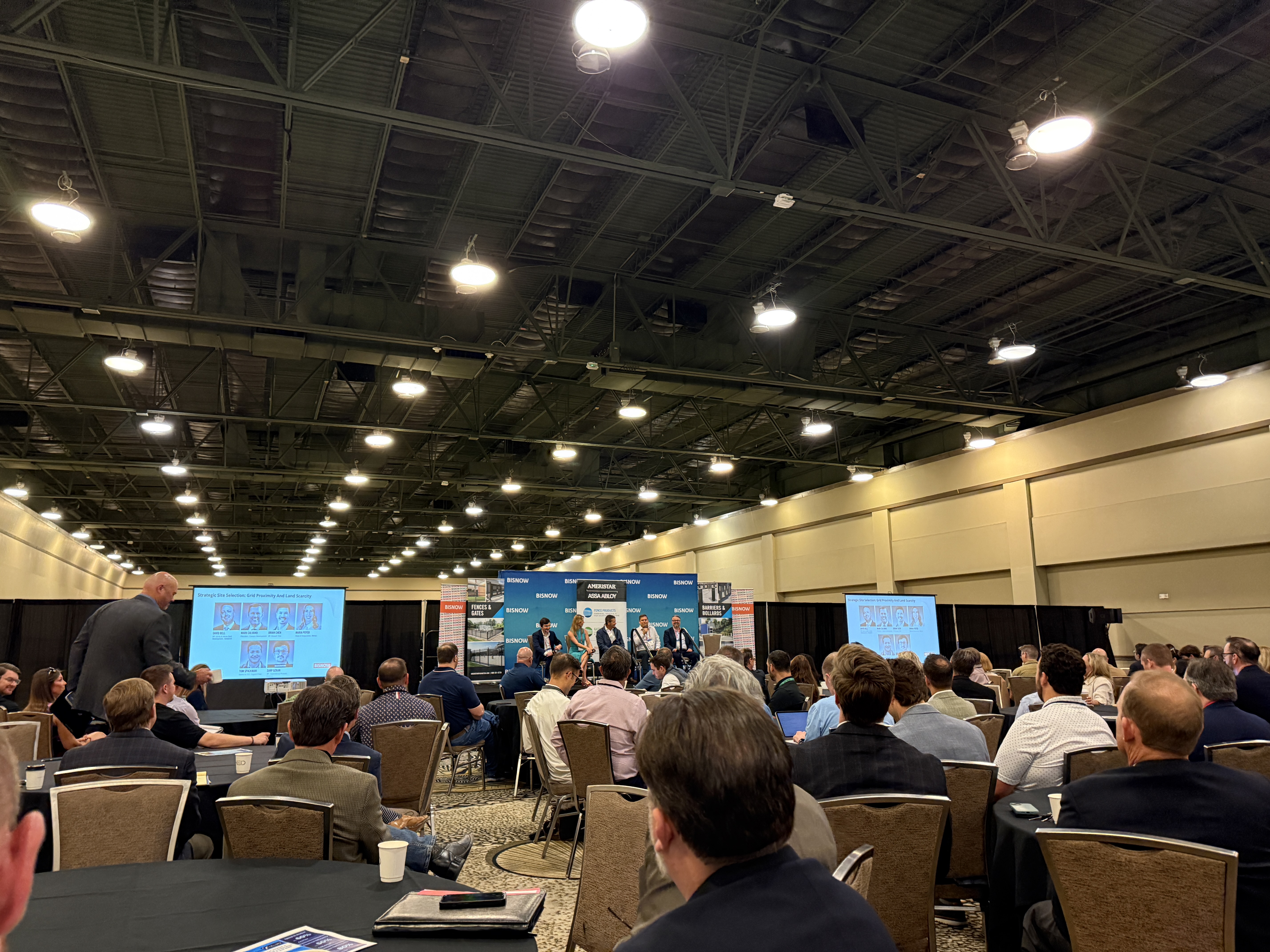 Busy conference hall watching a panel onstage at Bisnow Data Center Construction Conference